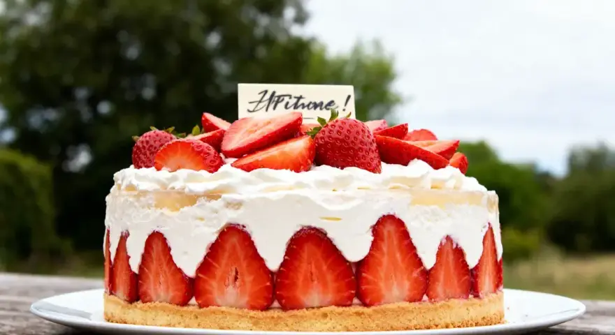 Délicieuse charlotte aux fraises sans gélatine, garnie de crème fouettée et de fruits frais. Un régal pour les yeux et les papilles !