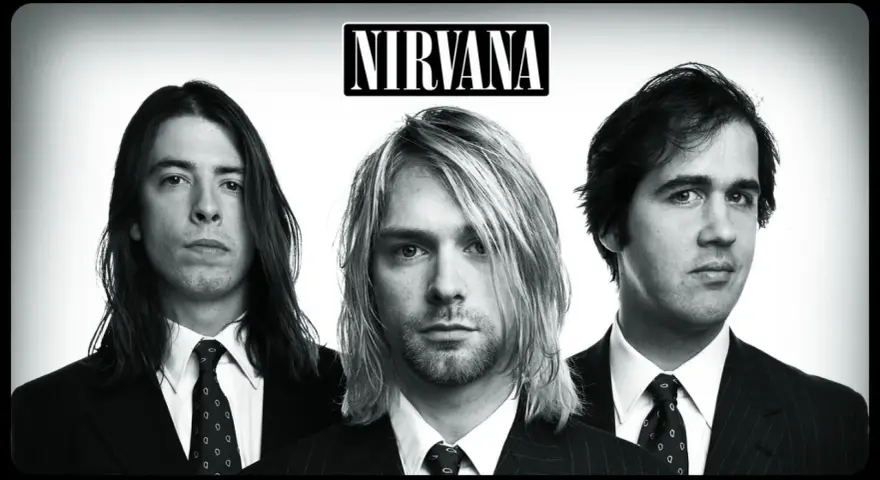 Le groupe Nirvana, pionnier du grunge, pose en noir et blanc. Kurt Cobain au centre, Dave Grohl à gauche, Krist Novoselic à droite. Un style musical iconique.