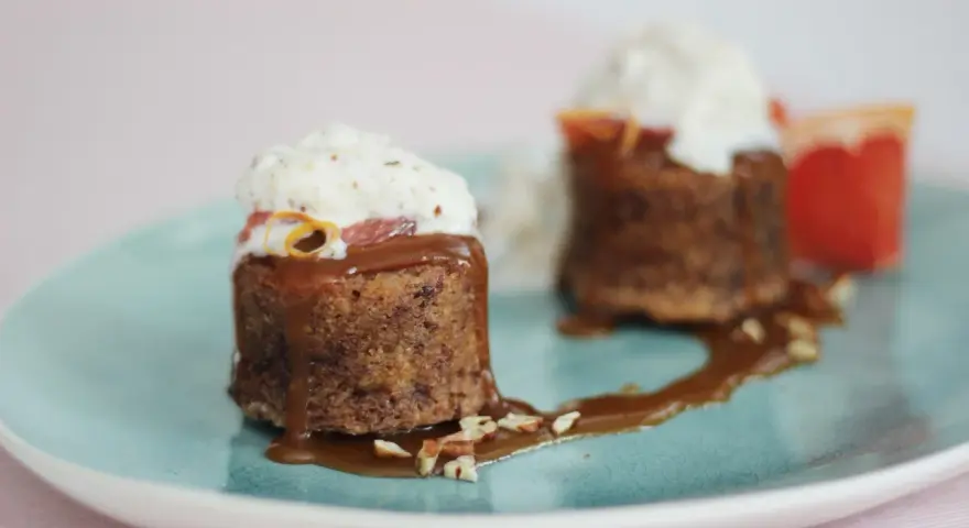 Zwei kleine Kuchen mit Karamellsauce, Nüssen und Sahne. Die süße Glucose-Verwendung macht sie unwiderstehlich.
