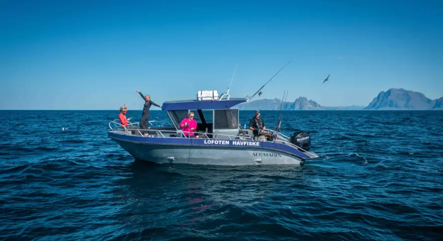 Fisketur i Nordnorge med båten "Lofoten Havfiske". Soligt och blåsigt, med berg i bakgrunden.
