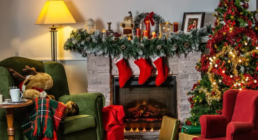 Acogedora sala con chimenea, árbol de Navidad y sillones. Una decoración navideña sostenible que invita a la calidez del hogar.