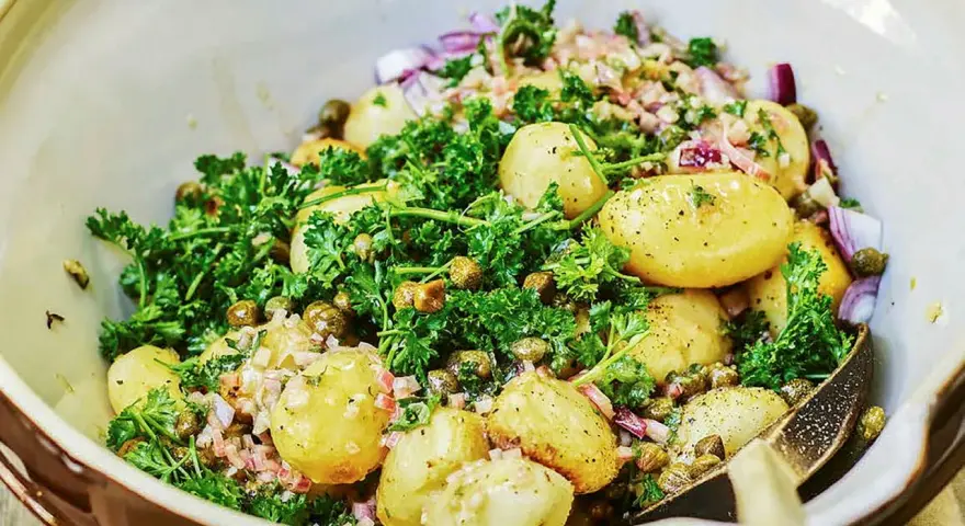 Fransk potatissallad dagen innan, med små potatisar, kapris, rödlök och persilja i en krämig dressing.
