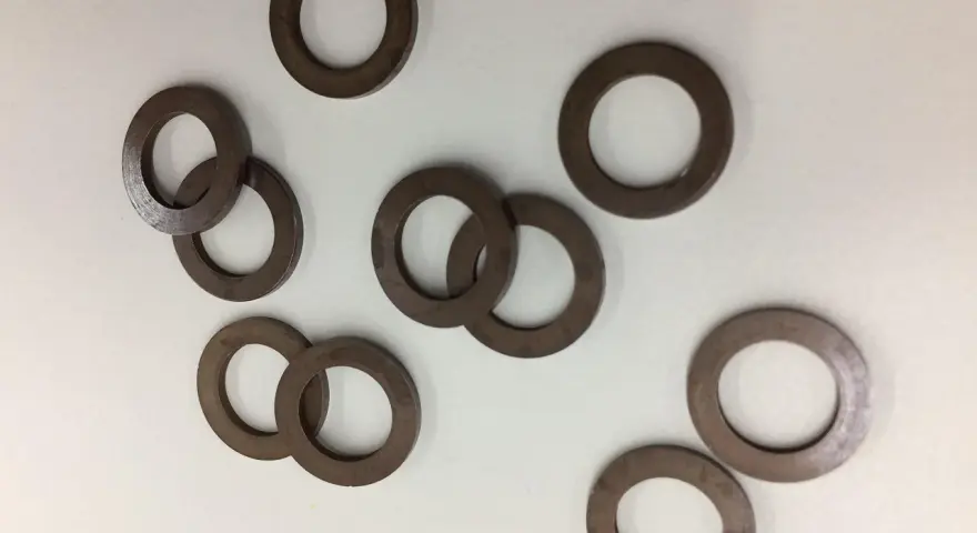 Un gruppo di rondelle alzaporta marroni, usate per regolare l'altezza delle porte.