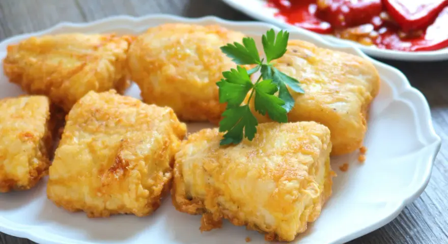Crujientes trozos de merluza a la romana, dorados y listos para disfrutar. Un clásico plato español.
