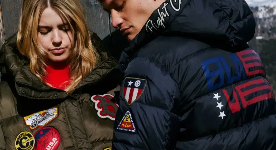 Para młodych w puchowych kurtkach. Ona w zielonej z naszywkami Blauer, on w granatowej z napisem "Flight Crew" i amerykańskimi motywami.