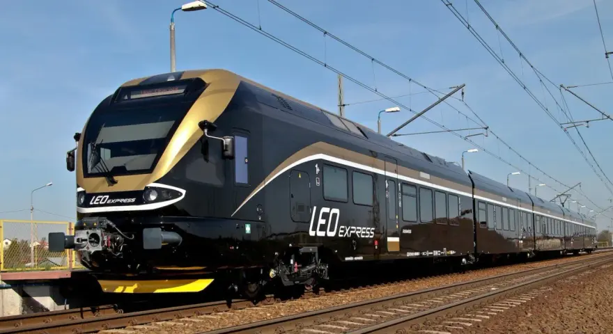 Nowoczesny, czarny pociąg LEO Express ze złotymi akcentami na torach.