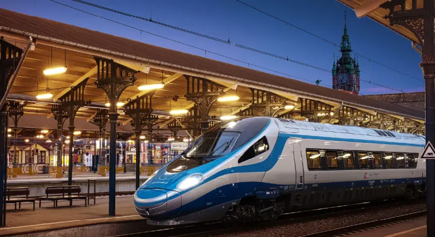 Pendolino Kraków-Gdańsk na dworcu w Gdańsku. Nowoczesny pociąg Intercity czeka na pasażerów pod zabytkową wiatą.