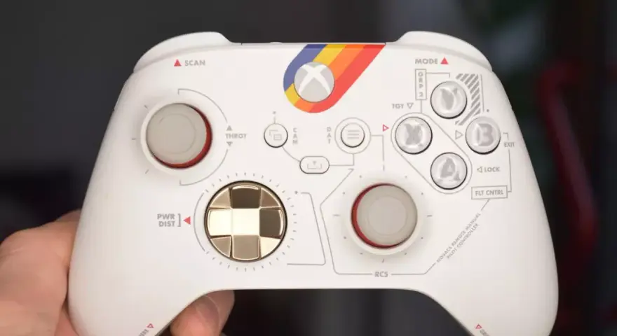 Biały kontroler Xbox z tęczowym paskiem i oznaczeniami przypominającymi kokpit. Idealny do testów xbox pad.