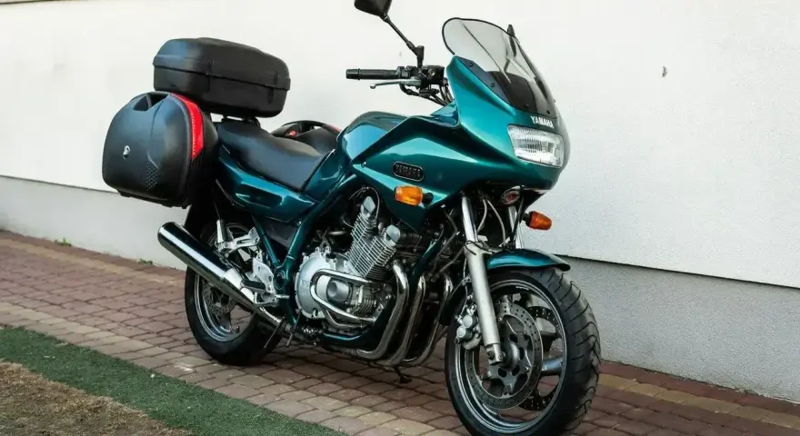 Zielony motocykl Yamaha XJ 900 z kuframi, gotowy na dalekie podróże.