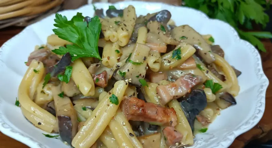 Un piatto invitante di pasta alla boscaiola con funghi e pancetta, guarnito con prezzemolo fresco.