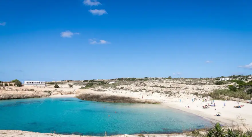 La **Cala Croce a Lampedusa** offre acque cristalline e una spiaggia dorata, ideale per rilassarsi sotto il sole.