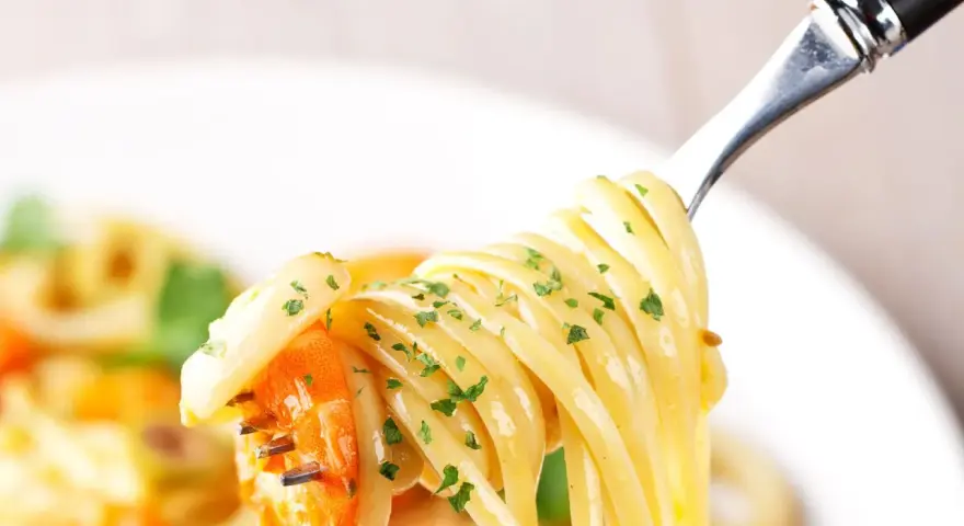 Un primo piatto invitante: spaghetti con gamberetti succulenti e prezzemolo fresco, pronti per essere gustati.