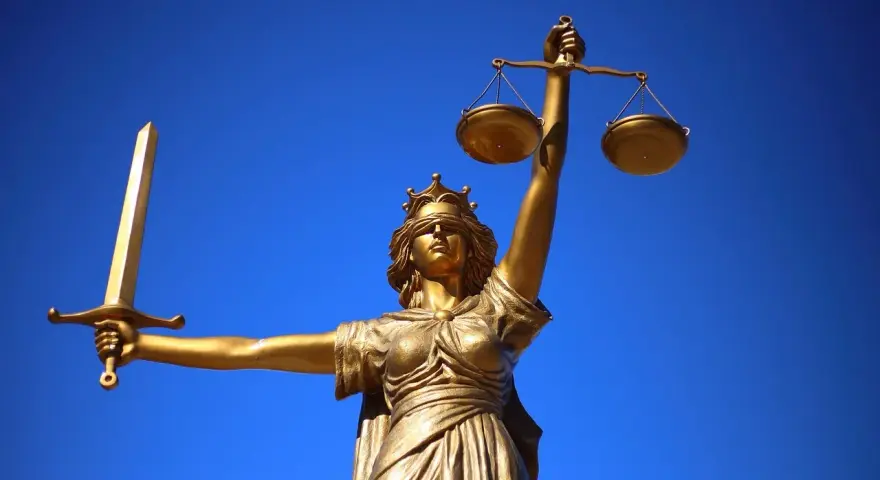 Złota Temida z mieczem i wagą, symbol sprawiedliwości, jak europejski tytuł egzekucyjny.