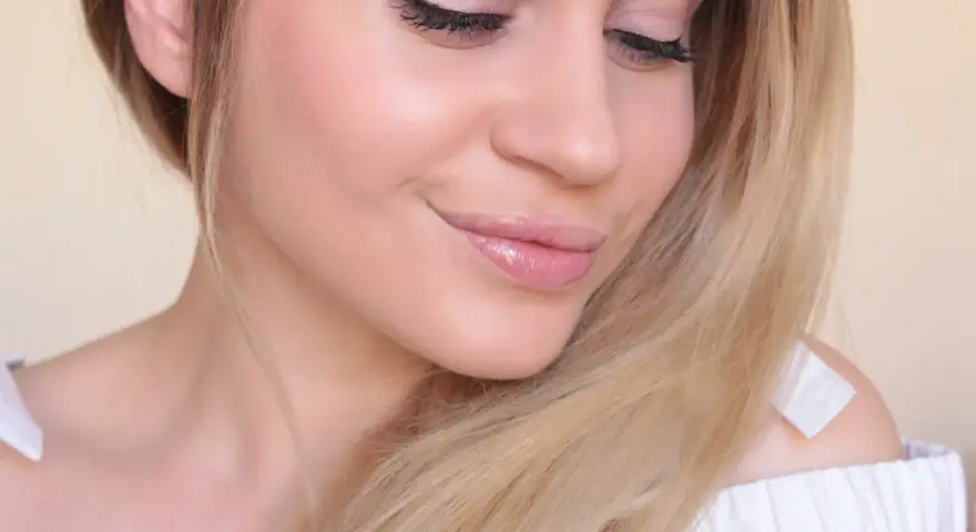 Un maquillage nude subtil rehausse la beauté naturelle de cette jeune femme aux cheveux blonds.