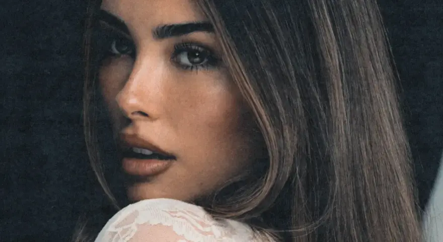 Zbliżenie na twarz Madison Beer, zmysłowe spojrzenie i delikatny uśmiech. Fani Madison Beer Polska czekają na jej powrót.