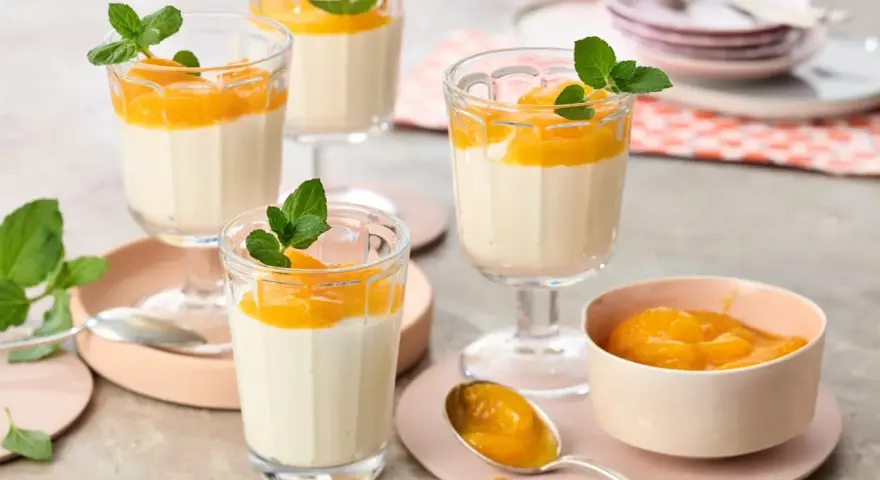 Leckeres Quarkspeise Rezept: Cremige Desserts mit Mandarinen und Minze in Gläsern serviert.