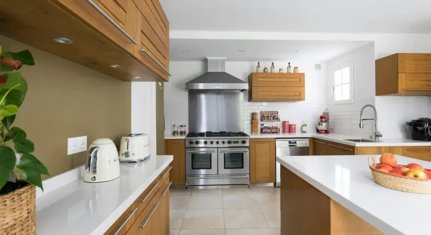 Cuisine moderne avec îlot central, électroménagers en inox et bois. Idéal pour estimer le prix rénovation maison m2.