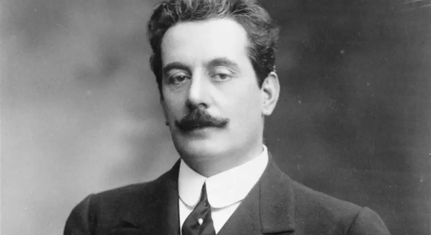 Giacomo Puccini, kompozytor słynnych **puccini opery**, w eleganckim garniturze i z charakterystycznymi wąsami.