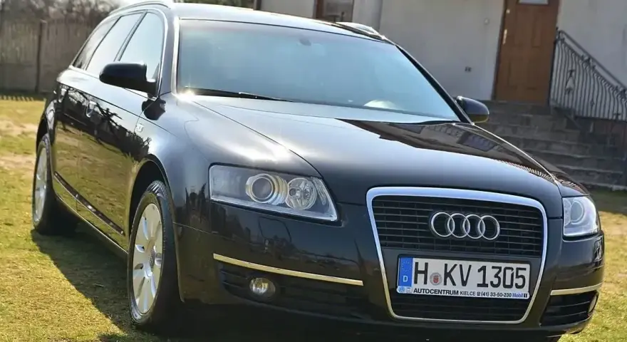 Czarny Audi A6 C6 3.0 TDI na trawie przed domem.