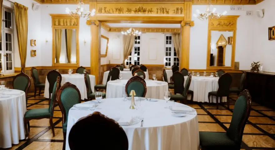 Elegancka sala bankietowa w lisewskim dworze, nakryte stoły czekają na gości.