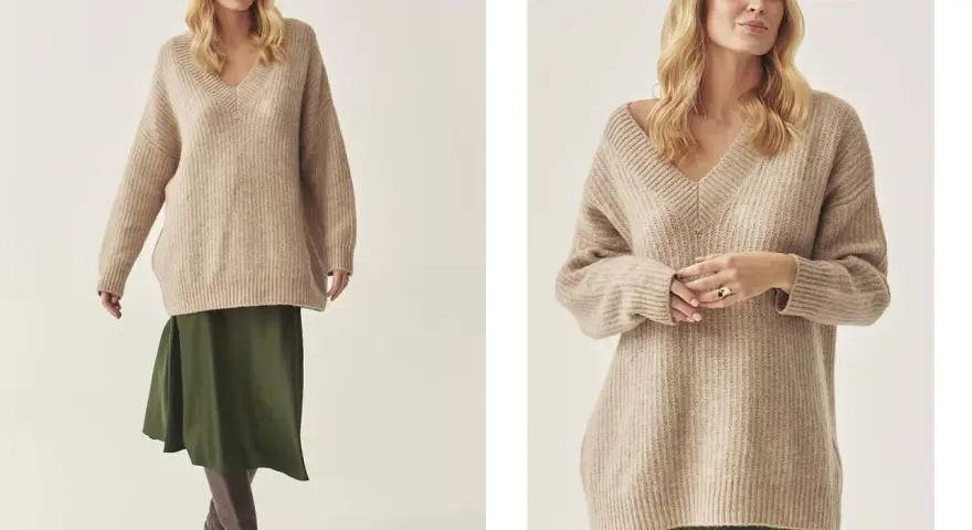 Modelka w beżowym swetrze w stylu oversize i zielonej spódnicy.