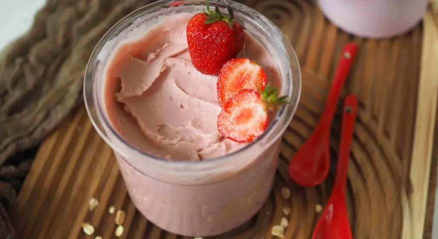 Cremiges Kefir Eis mit frischen Erdbeeren garniert, bereit zum Genießen.