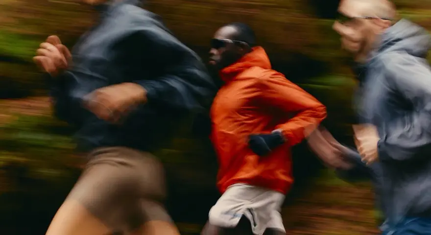 Trois coureurs en mouvement dans un décor forestier, suivant un programme reprise course à pied.
