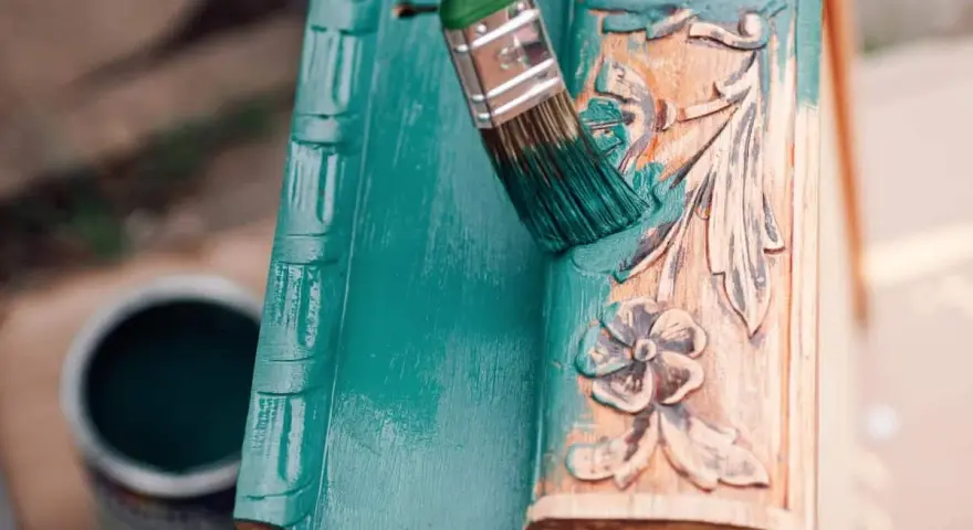 Pintura a la tiza verde turquesa cubriendo un marco de madera tallada.