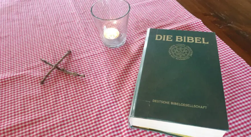 Ein Kreuz aus Zweigen, eine Kerze und die Bibel, die uns an Jesaja 43,19 erinnert: "Siehe, ich will ein Neues machen.