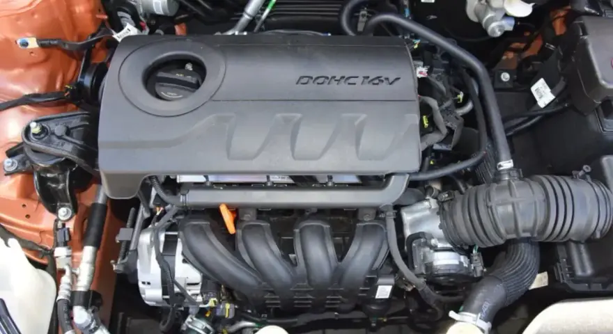 Silnik MPI DOHC 16V, widok z góry. Widać kolektor dolotowy, osłonę silnika i elementy układu dolotowego.