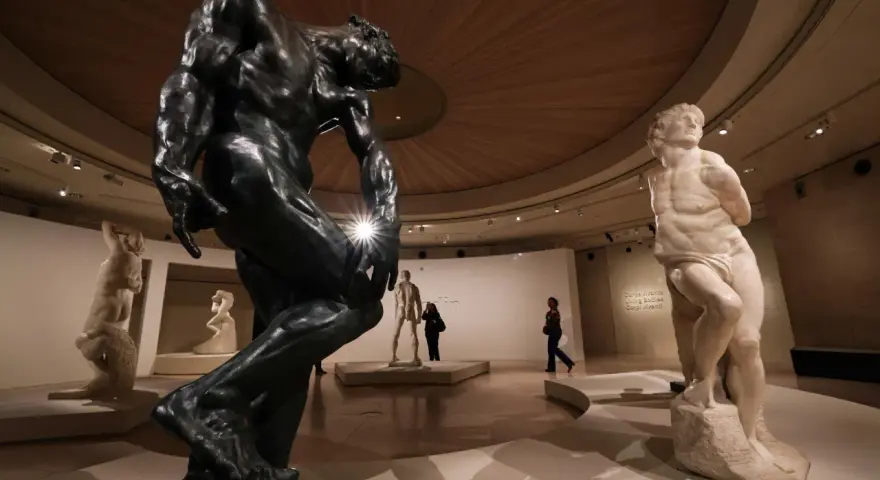 Musée d'art présentant des sculptures de sculpteurs célèbres, dont une grande statue en bronze et une statue en marbre.