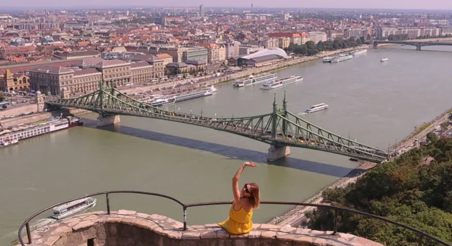Widok na Dunaj w Budapeszcie z zielonym mostem i kobietą w żółtej sukience.