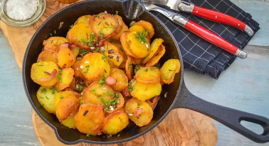 Goldbraune Bratkartoffeln mit Speck und Schnittlauch in der Pfanne. Perfekt als Beilage, denn dazu passt fast alles!