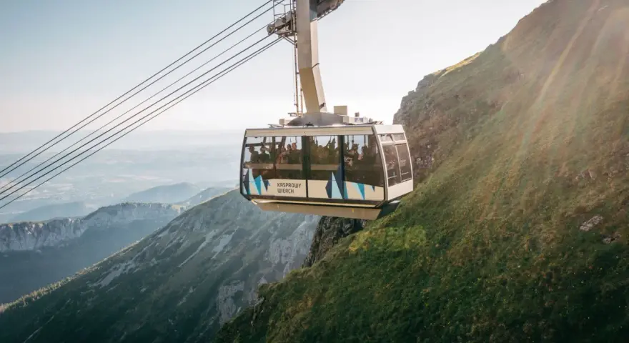 Kolejka na Kasprowy Wierch wwozi turystów na szczyt. Widok z wagonika zapiera dech w piersiach, ukazując malownicze Tatry.