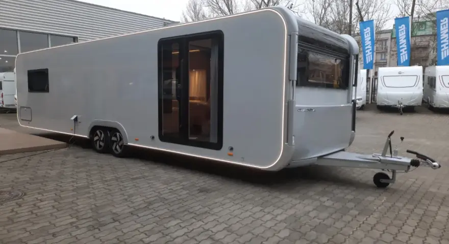 Nowy Adria Astella 904 HP, luksusowy caravan z panoramicznymi oknami i nowoczesnym designem, gotowy na podróże.