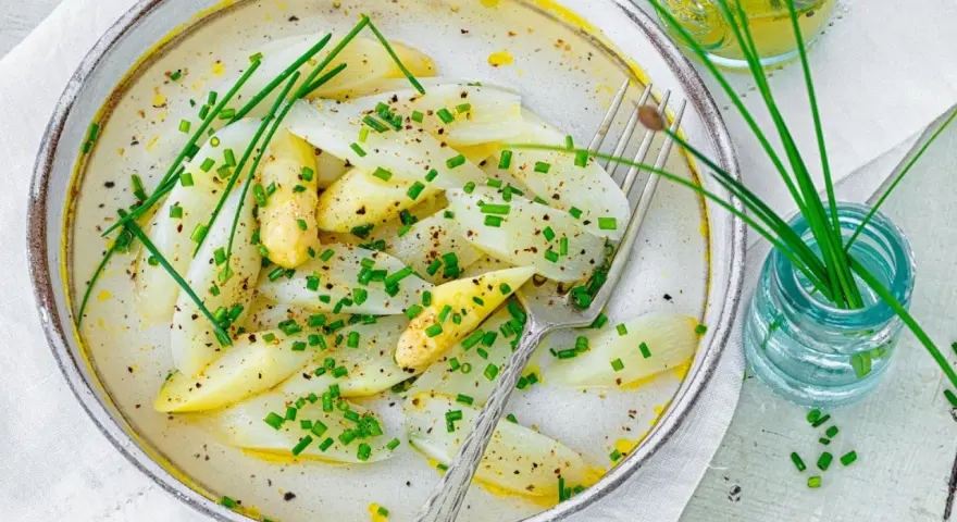 Spargel mal anders: zarte weiße Spargelstücke in einer cremigen Sauce, garniert mit Schnittlauch und Pfeffer. Ein leichter Genuss.