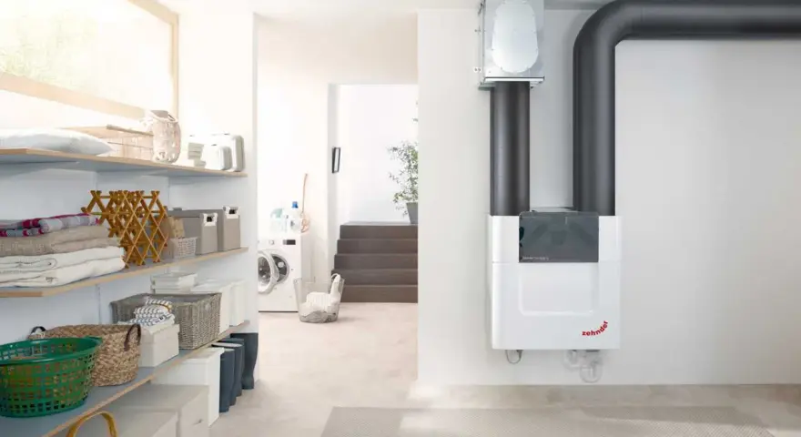 Sistema de ventilación con recuperación de calor Zehnder ComfoAir Q, con tuberías grises y un diseño blanco moderno.