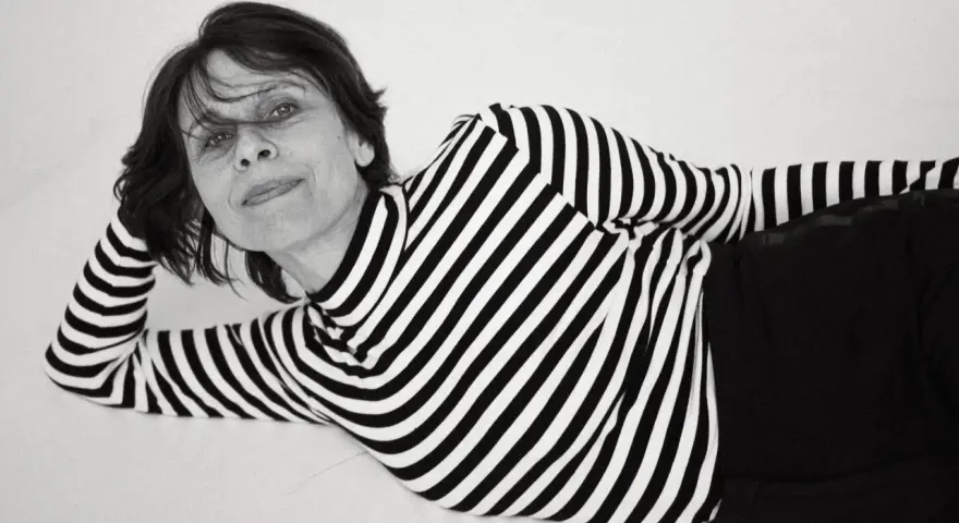 Katarzyna Krzanowska w czarno-białym swetrze w paski, leżąca na boku, z ręką pod głową.