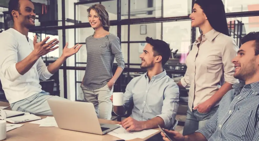 Un gruppo di persone in un ufficio moderno discute animatamente. I colleghi non sono amici, ma lavorano insieme con professionalità.