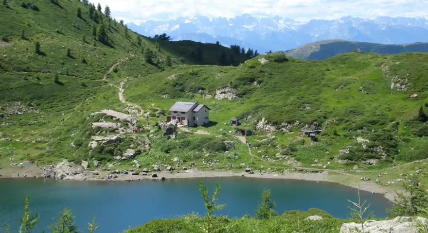 Sentiero per il lago di Erdemolo, con rifugio e montagne sullo sfondo.