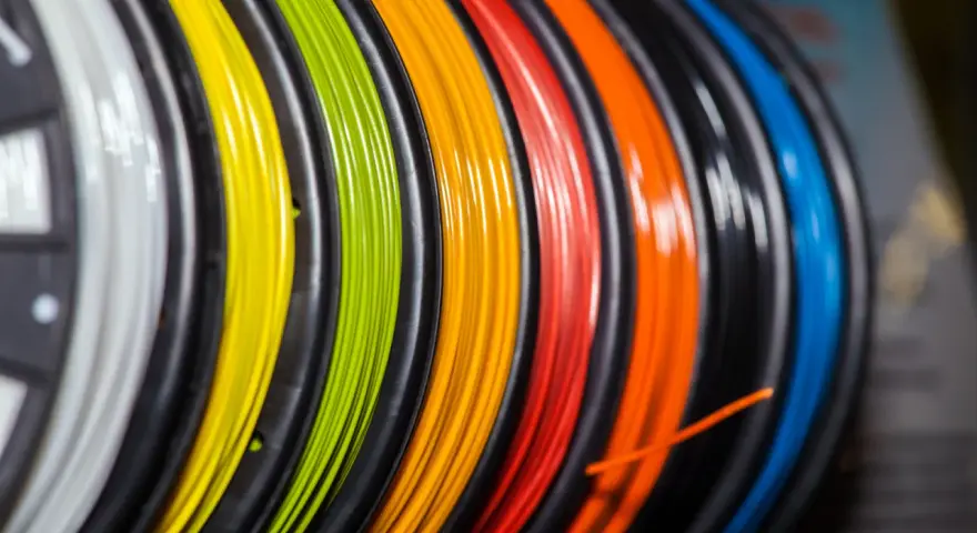 Kolorowy filament do druku 3D, nawinięty na szpulki. Zastanawiasz się, filament co to? To materiał do tworzenia trójwymiarowych obiektów.