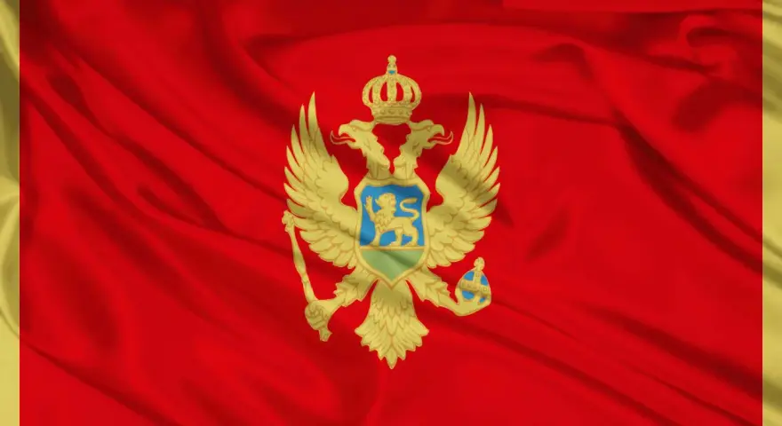 Flaga Czarnogóry z dwugłowym orłem i koroną na tle czerwonego materiału.