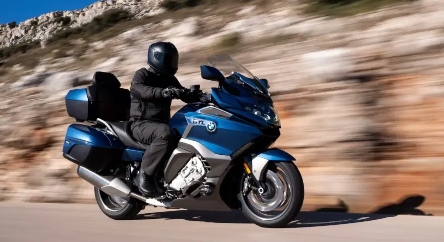 Motocyklista w kasku przemierza malowniczą trasę, odkrywając różne rodzaje turystyki.