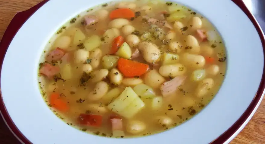 Aksamitna zupa fasolowa przepis babci, pełna białej fasoli, ziemniaków, marchewki i kawałków wędzonki. Aromatyczna i sycąca.