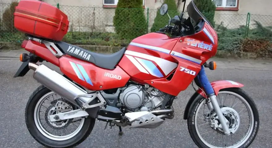 Czerwony motocykl Yamaha XTZ 750 Super Tenere, gotowy na przygodę. Dane techniczne tego modelu są imponujące.