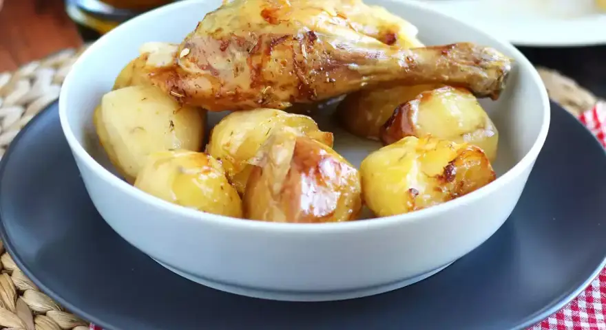 Un invitante pollo al forno con patate dorate, un classico piatto che profuma di casa.