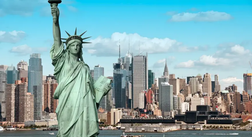 Statua Wolności wita na wycieczce do USA. W tle panorama Nowego Jorku z drapaczami chmur.