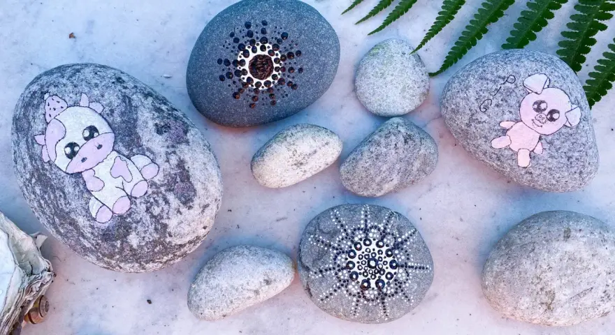 Söta djur på stenar: en ko med prickar och en rosa gris. Måla djur på sten är en rolig hobby.