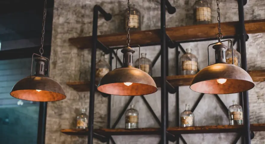 Industrialne lampy wiszące nad półkami ze słoikami. Dowiedz się, jak wyczyścić abażur z lampy, by odzyskał dawny blask.