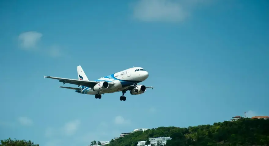 Samolot pasażerski z niebieskimi pasami na tle błękitnego nieba. Może to być przypomnienie o możliwości zwrotu biletu Ryanair zwrot biletu 24h.